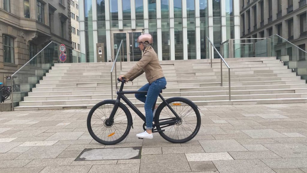 Frau fährt in der Stadt mit einem E-Bike