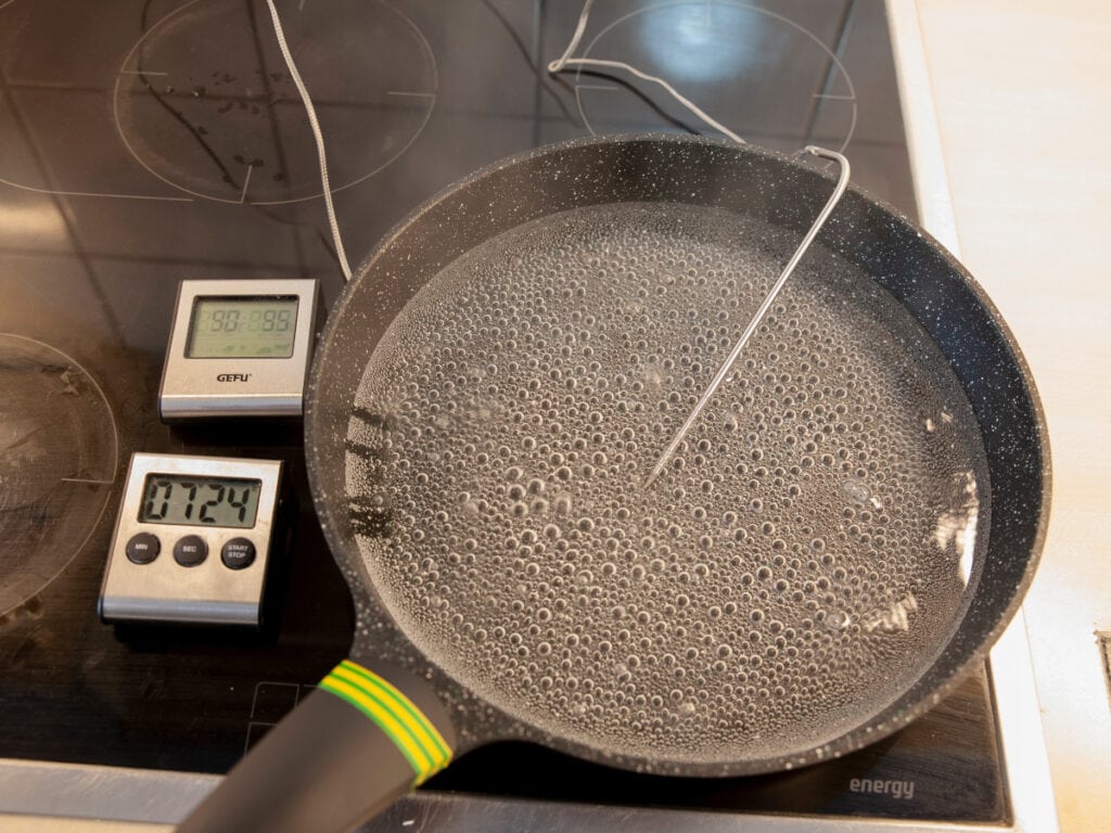 Kochendes Wasser in Pfanne mit Thermometer