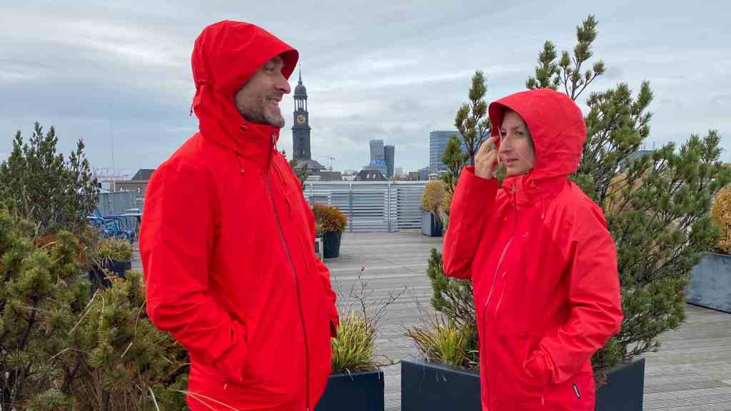 Ein Mann und eine Frau in roten Regenjacken vor grauem Himmel
