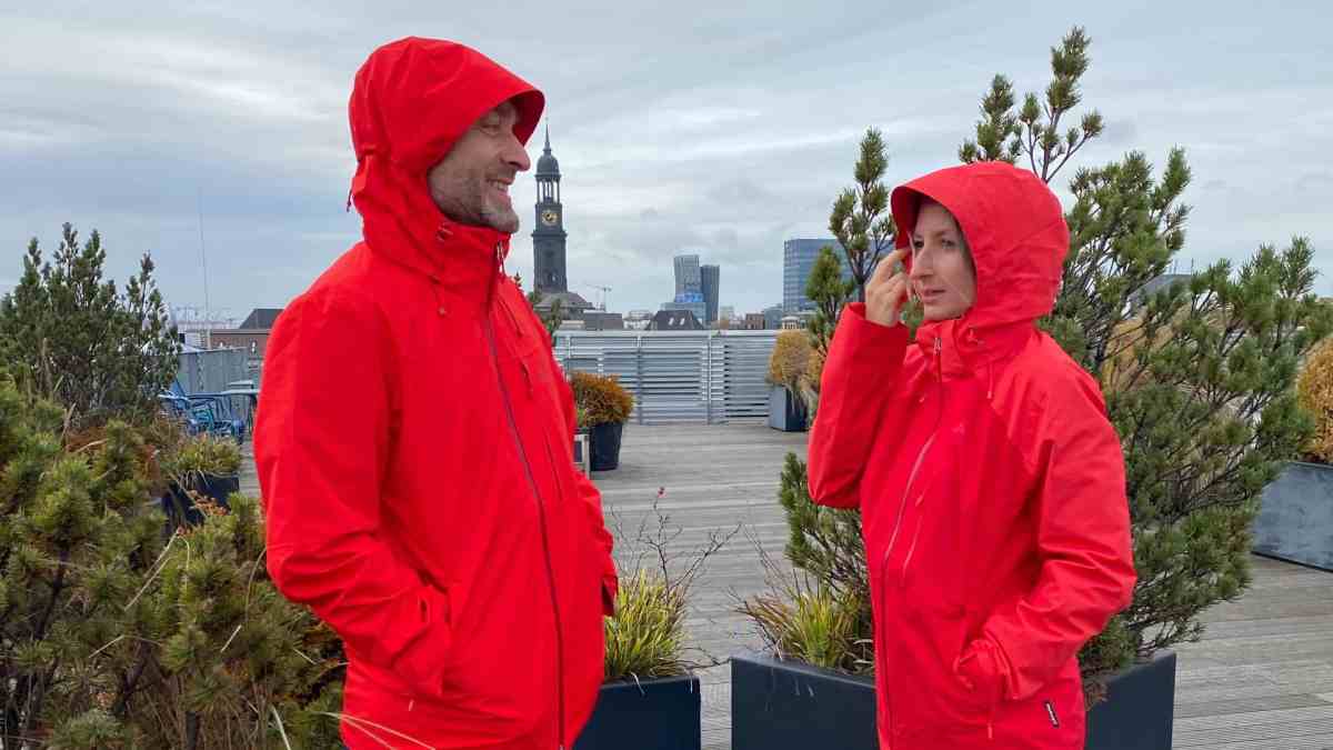 Ein Mann und eine Frau in roten Regenjacken vor grauem Himmel