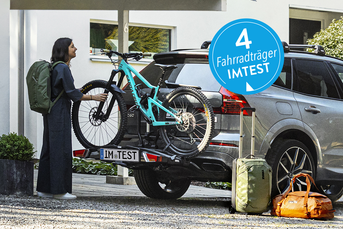 Eine Frau steht an einem AUto mit Fahrradträger