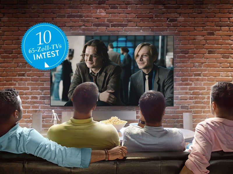 Vier Männer schauen ein Fußball-Spiel auf einem 65-Zoll-Fernseher.