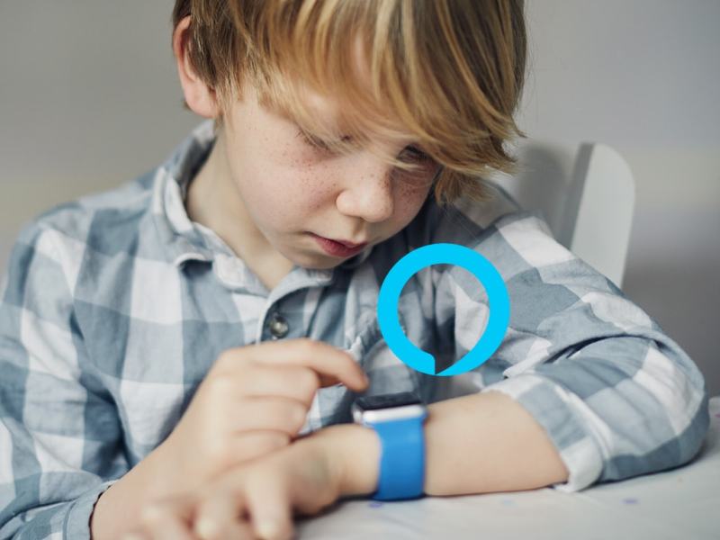 Ein Kinde spielt an seiner Smartwatch am Handgelenk.