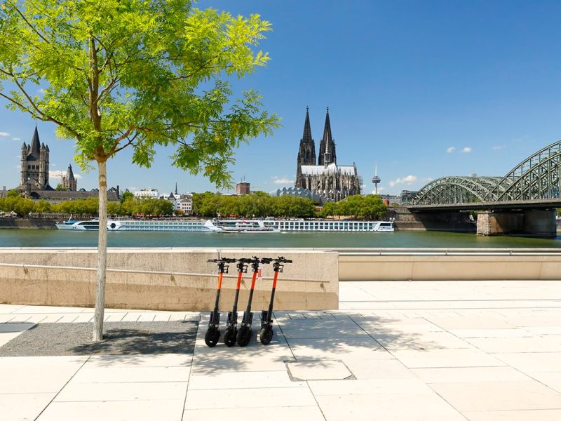 E-Roller stehen am Ufer des Rheins in Köln.