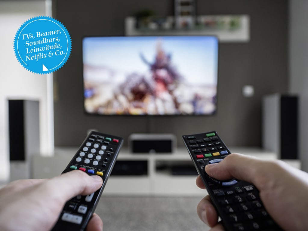 Zwei Fernbedienungen vor dem Fernsehen.