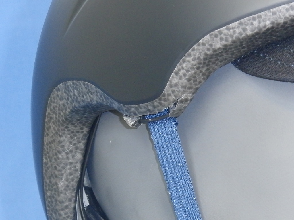 Detailaufnahme von Abus-Helm zeigt Riss im Styropor an Befestigung des Riemens