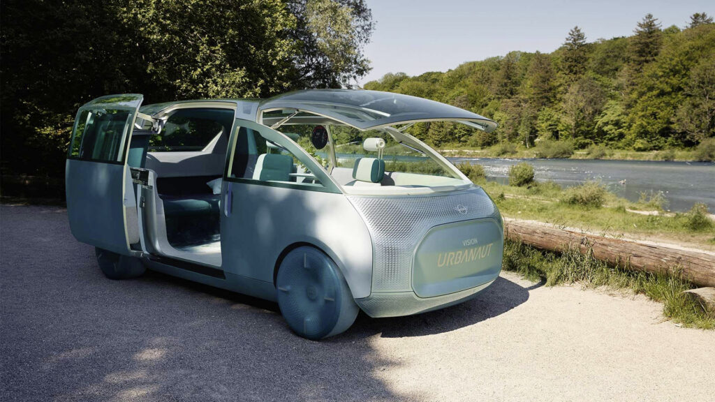 Türkises futuristisches Elektro-Auto am Flussufer im Wald