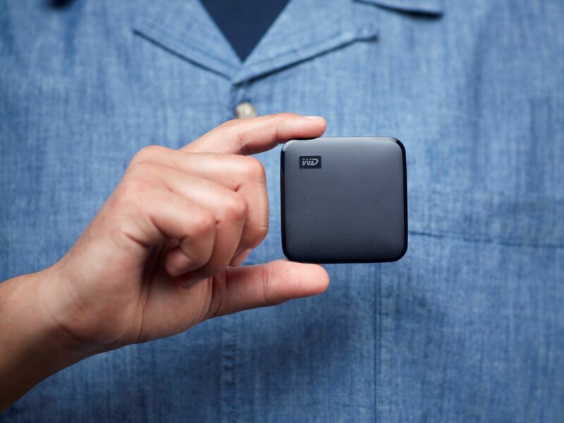 Ein Mann hält eine SSD-Festplatte in der Hand.