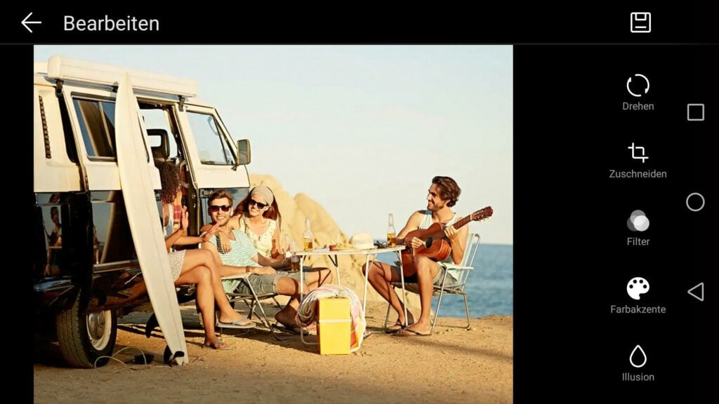 Foto von Freunden am Strand mit Bulli auf Stühlen sitzend geöffnet in Smartphone-Galerie