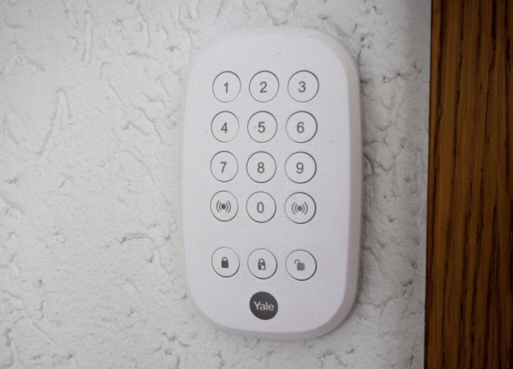 Weißes Keypad für Alarmanlage auf weißer Wand