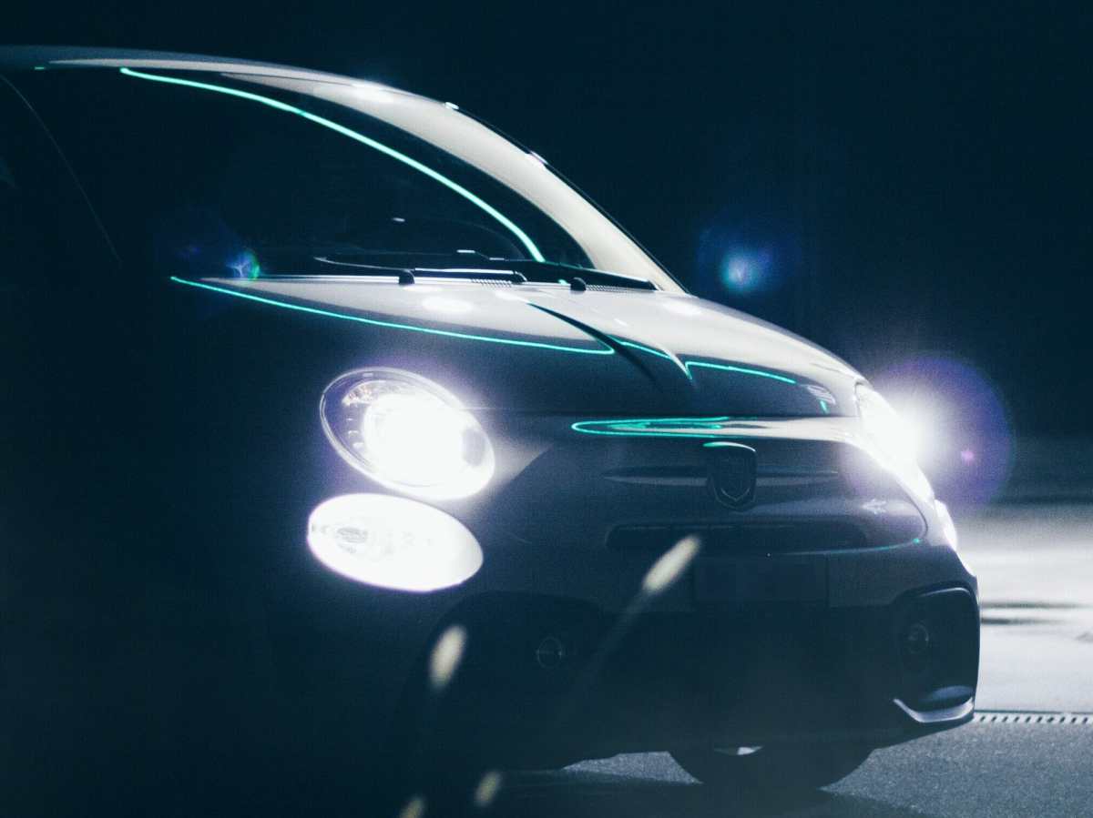 Ein Auto bei Nacht mit leuchtenden Scheinwerfern.