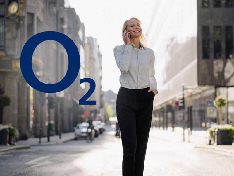 Business Frau telefonierend auf offener, heller Straße, daneben das Logo von o2