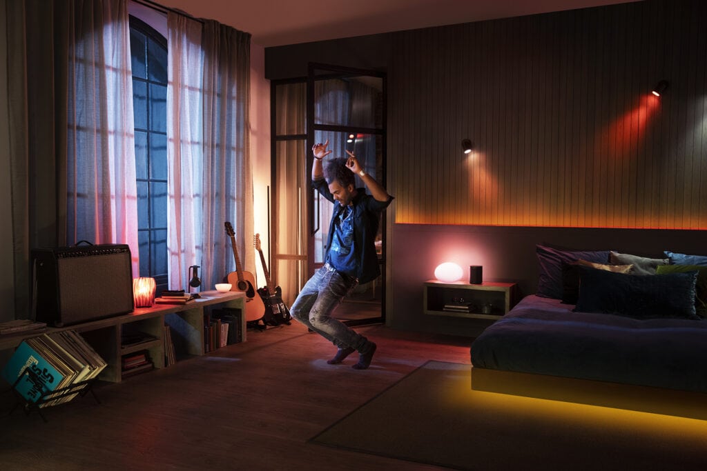 Mann tanz in Zimmer mit Philips Hue.