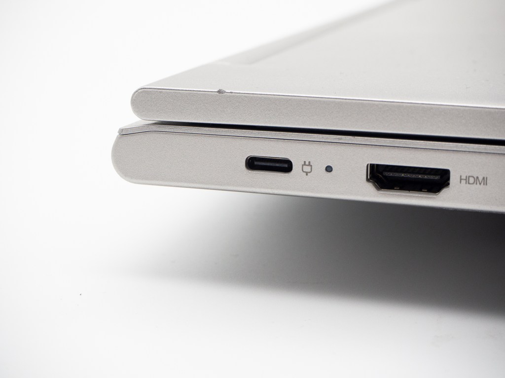 Detail zugeklapptes silbernes Notebook mit USB-Ports auf weißem Hintergrund