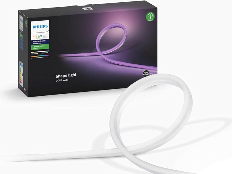 Weißer Streifen schlägt Schlaufe im Vordergrund, im Hintergrund die Verpackung von Philips Hue Lightstrip