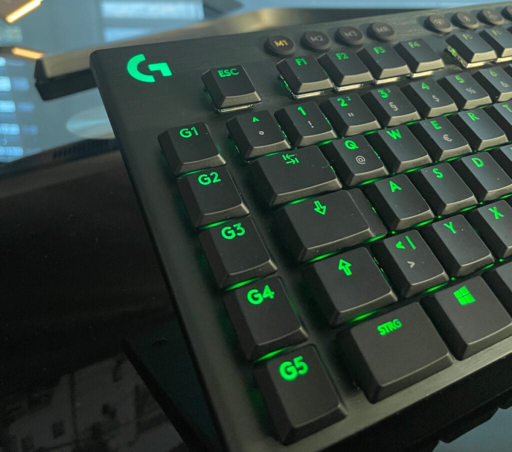 linke Hälfte von schwarzer Tastatur mit grün leuchtenden Tasten schräg von vorne