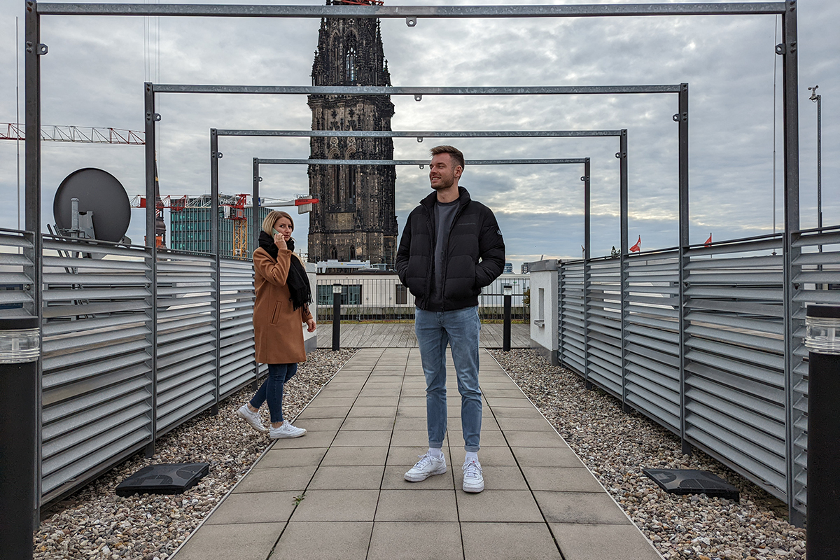 Zwei Personen stehen vor einem Kirchturm