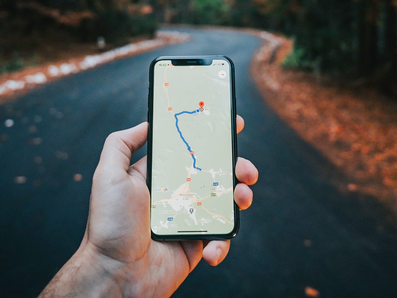 Hand die ein Smartphone hält, mit geöffneter Navigation.