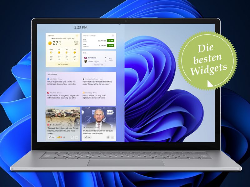 Aufgeklappter Laptop mit aufgeklappter Startleiste vor blauer Schleife auf schwarzem Hintergrund
