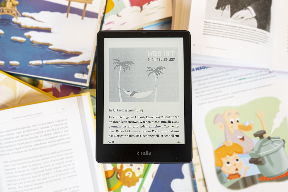 Schwarzer E-Book-Reader mit geöffneter seite vor verschiedenen Texten mit bunten Bildern