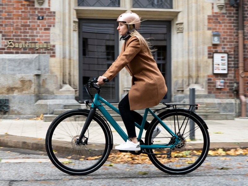 Frau fährt auf dem türkisen Bike BEZN Brussels.