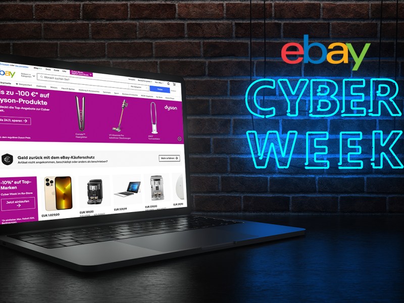 notebook aufgeklappt mit eBay Seite vor dunklem Hintergrund daneben Cyber Week in Neonschrift und eBay Logo