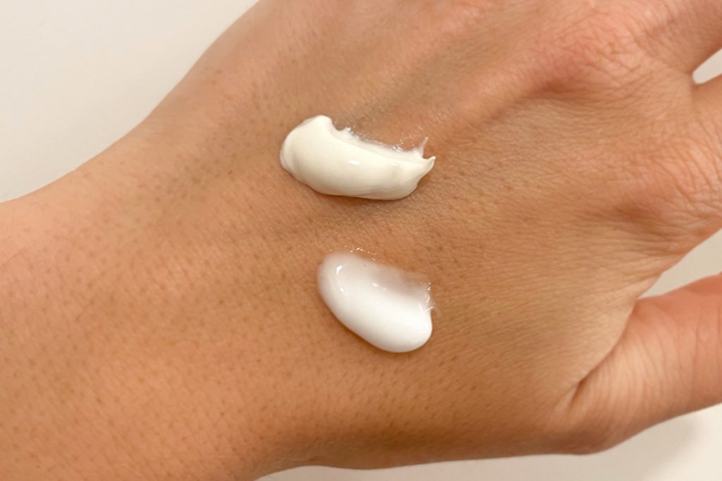 Hand mit zwei Creme-Kleksen