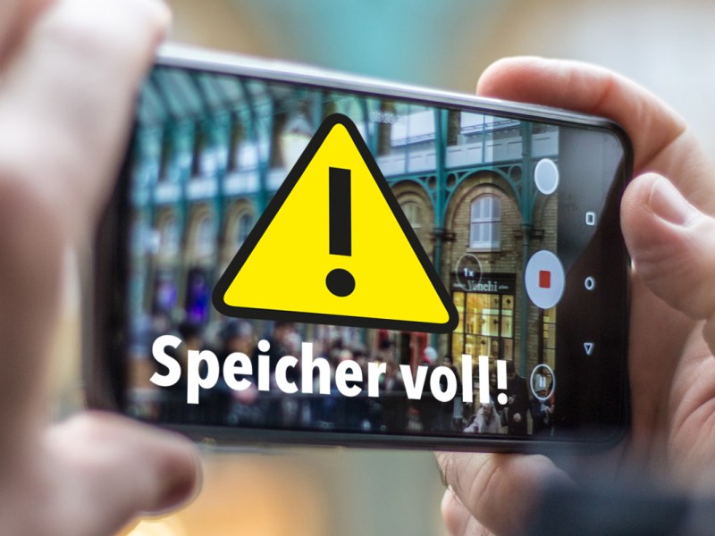 Hand hält Smartphone und macht Foto. Warnhinweis "Speicher voll!" erscheint.