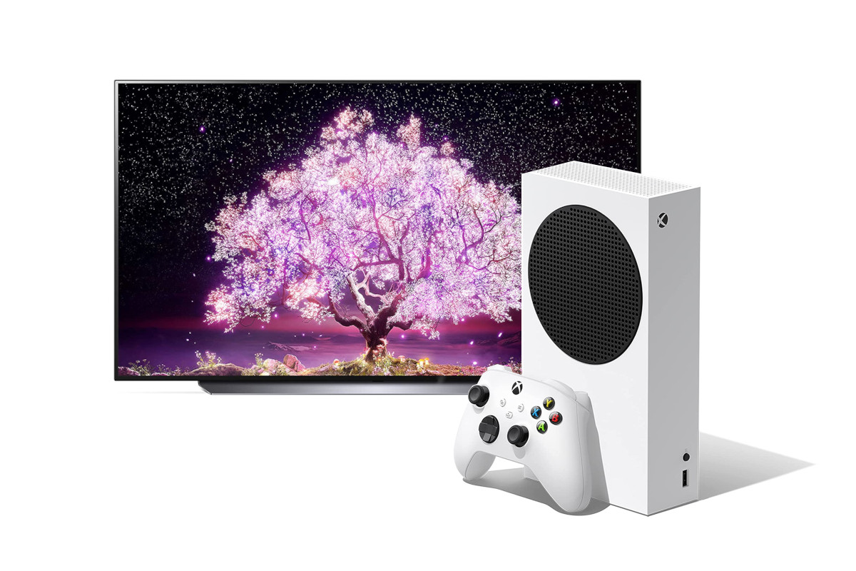 Fernseher zeigt lila Baum, davor weiße Xbox mit Kontroller
