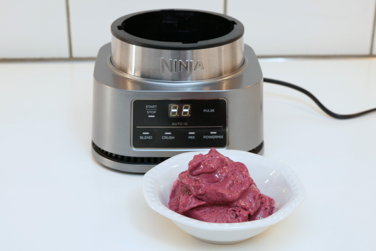 Weiße Schale mit pinkem Beeren Sorbet vor Standmixer