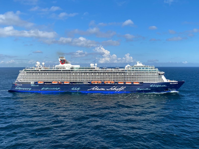 Blick schräg nach unten auf Wasser mit Kreuzfahrtschiff von der Seite