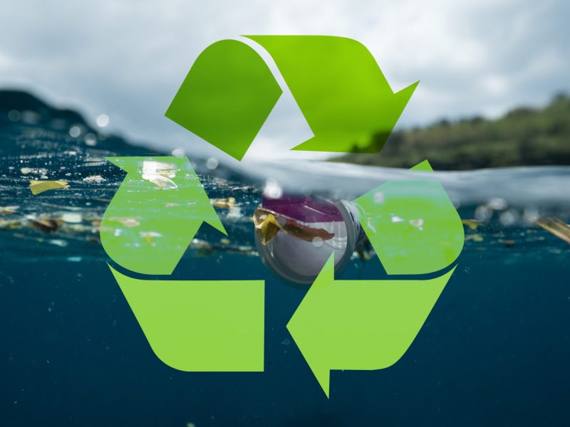 Im Meer treibender Plastikmüll, davor stehendes Recycling-Logo