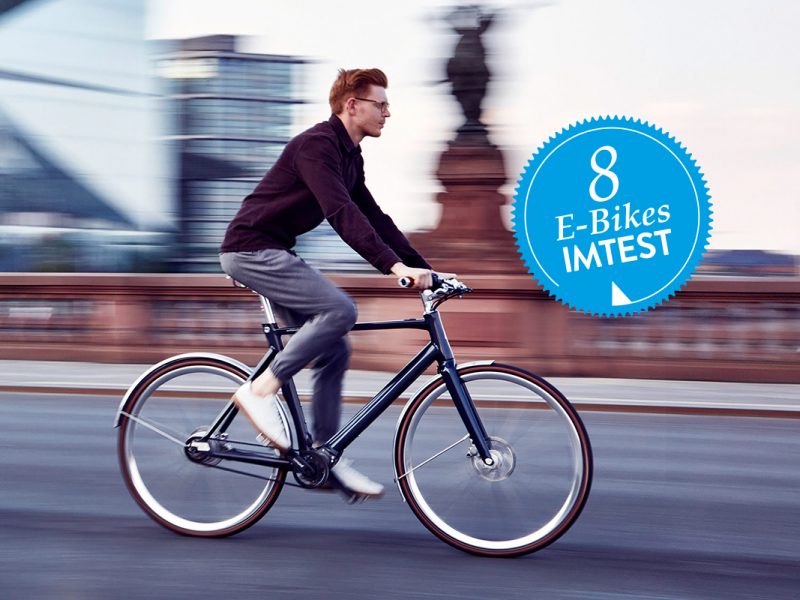 Ein Mann fährt auf einem dunkelblauen E-Bike