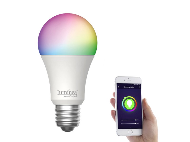 Leuchte in Kolbenform in verschieden leuchtenden Farben, daneben Hand, die Smartphone mit geöffneter App hält auf weißem Hintergrund