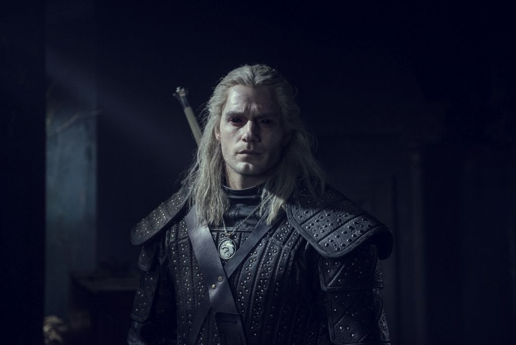 Mann mit blonden langen haaren in Mittelalter-Kleidung vor dunklem Hintergrund