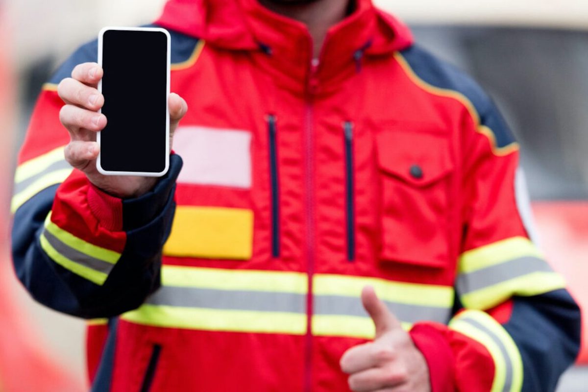 Ein Feuerwehrmann hält ein Smartphone