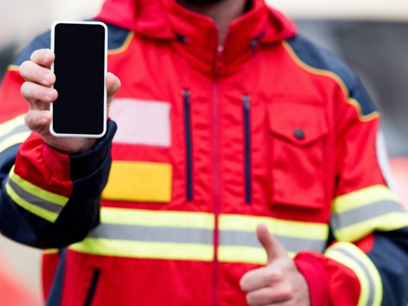 Ein Feuerwehrmann hält ein Smartphone