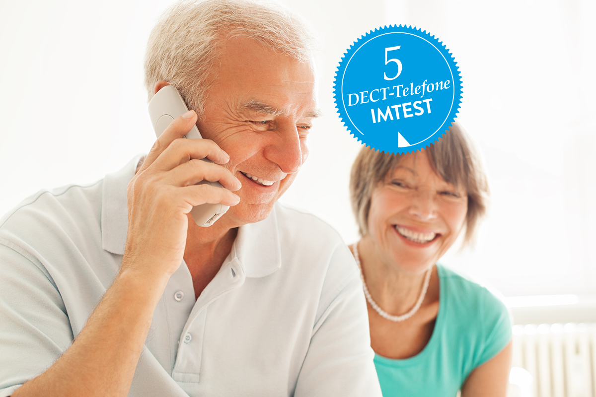 Älterer Mann von der Seite telefoniert mit DECT-Telefon, ältere lächelnde Frau im Hintergrund; blauer Störer mit "5 DECT-Telefone IMTEST"