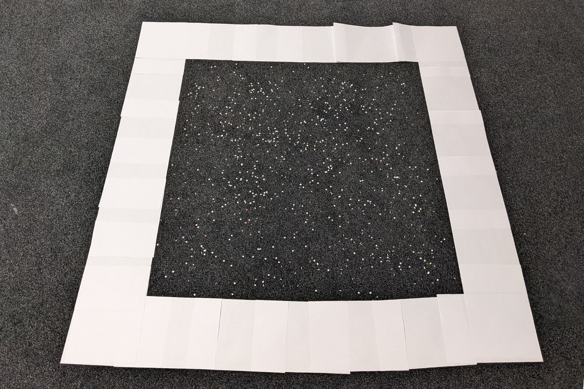Grauer Boden mit weißem Konfetti in weißem Papierrahmen