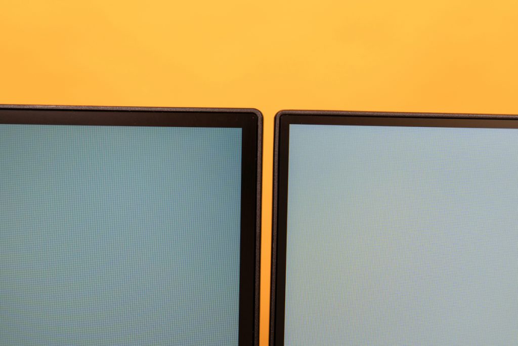 Detail zwei Monitor Ecken vor orangenem Hintergrund