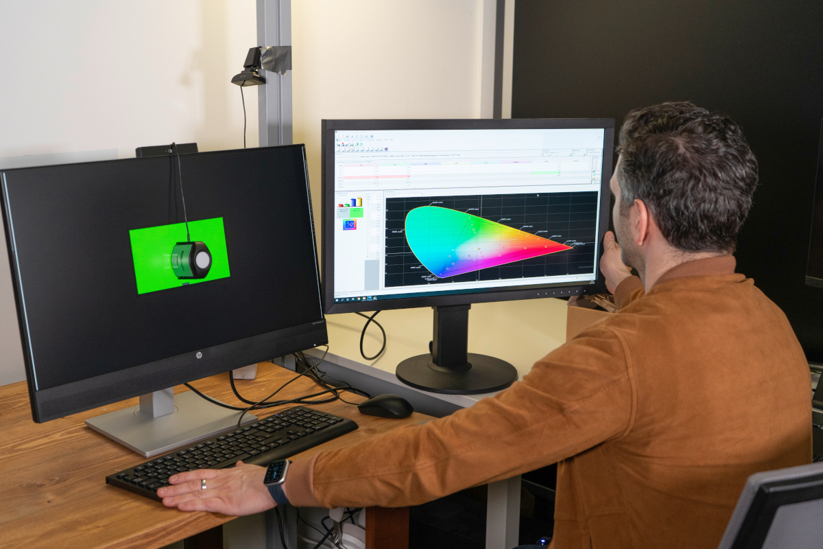 Home-Office-Monitor im Test:Mann von hinten sitzt vor zwei Monitoren, die Farbverläufe zeigen