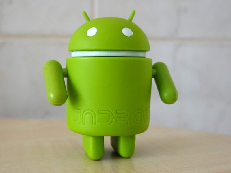 Grüne Android-Figur auf hellbrauner Tischplatte