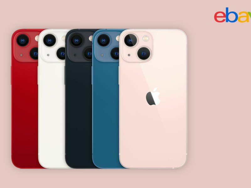 Fünf verschieden farbige iPhone 13 aufgereiht mit Rückseite nach vorn auf rosanem Hintergrund mit eBay Logo in der rechten Ecke