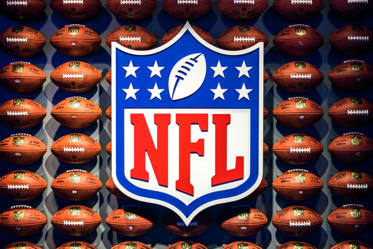 NFL Logo vor Regal mit vielen Footballs