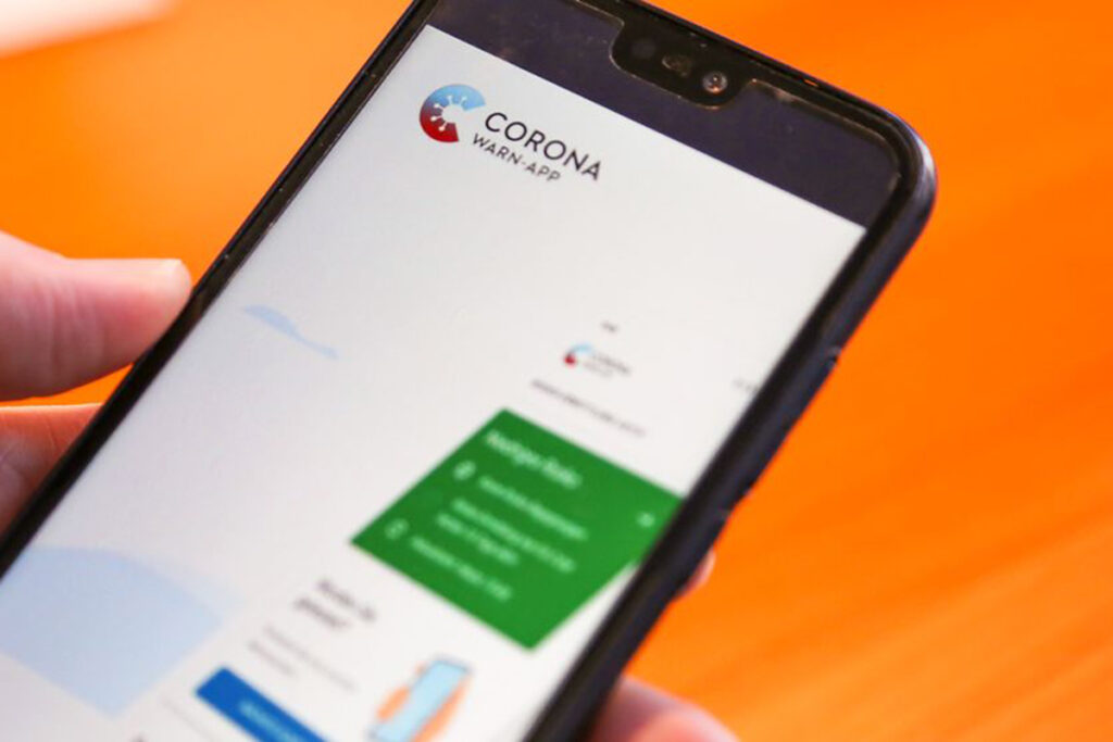 Smartphone in den Händen eines Mannes beim Bedienen der Corona-Warn-App.