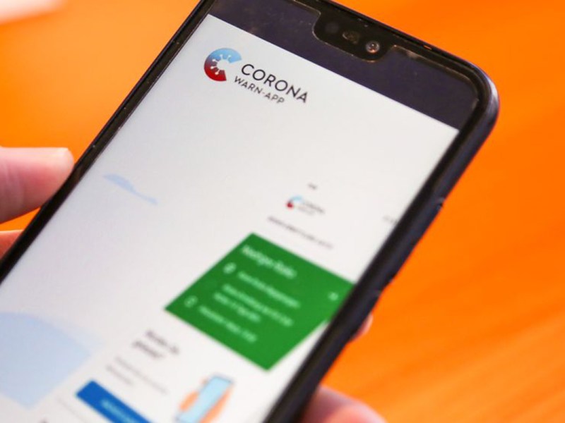Smartphone in den Händen eines Mannes beim Bedienen der Corona-Warn-App.