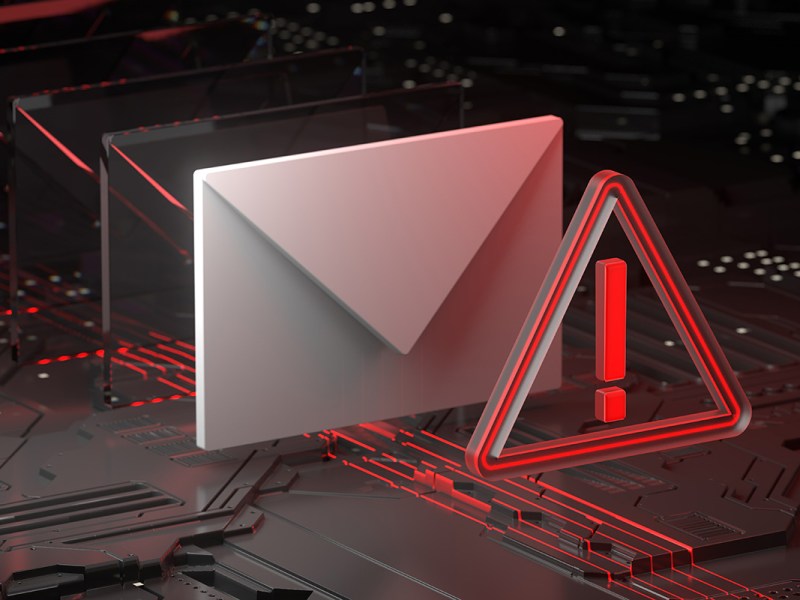 Ein Warmsymbol steht vor einem digitalen Brief als symbolische Warnung vor einer Phishing-Mail