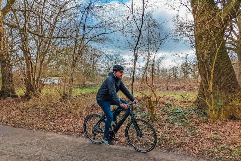 Mann auf Urban-E-Bike auf Waldweg