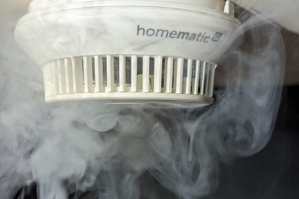 Weißer Rauchmelder von Homematic wird Rauch ausgesetzt