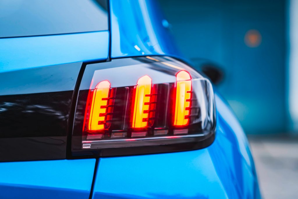 Detailaufnahme leuchtendes Rücklicht von blauem E-Auto